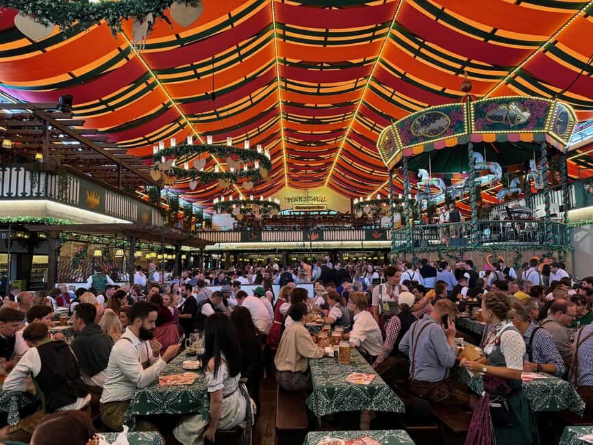 Munich: Oktoberfest tour with Weisswurst breakfast - GERMAN - At the Main Entrance to the Wiesn: Your Costumed Guide in Motion
